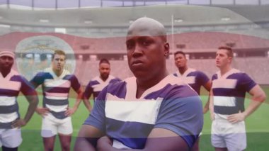 Rugby takım arkadaşları sahada duruyor, aşırı sol oyuncu topu tanıtıyor ve oyuna hazırlanıyor. Sporcular, takım, yoldaşlık, rekabet, spor, açık hava, dayanıklılık