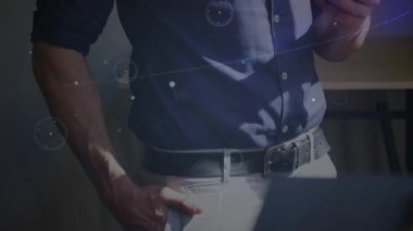 Ofiste akıllı telefon yetiştirip teknolojik verileri analiz etmek ve UI halkalarını canlandırmak için dinleme yapan olgun bir adam. Teknoloji, fütürizm, dijital, yenilik, profesyonel, gösterişli, bağlantı