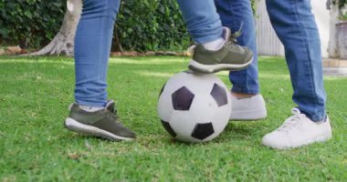 Asyalı anne ve kızının bahçede futbol oynamalarının videosu. Aile, annelik, ilişkiler ve birlikte kaliteli zaman geçirme konsepti dijital olarak oluşturulmuş video.