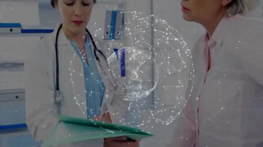 Doktor yeşil hasta dosyasını açıyor, sayfaları çeviriyor ve hastaya tıbbi detayları gösteriyor. Sağlık, danışma, profesyonellik, iletişim, güven, sağlık, tanı