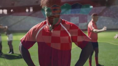 Spor atleti ellerini kalçalarına koyuyor bayrak kaldırmaya başlıyor, grup toplanıyor, geriniyor. Sporcu, takım çalışması, stadyum, performans, fitness, açık hava, kararlılık