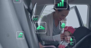 Anne kızını araba koltuğuna kaldırıyor, otomobil güvenliği için animasyon eko-ikonlarla emniyet kemeri takıyor. Ebeveynlik, güvenlik, çevre, sağlık, yetiştirme, aile, çevre bilinci