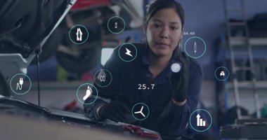 Otomotiv teknisyeni, motor aktifleştirici ışın üzerinde tanısal tarayıcı tutuyor ve simgeleri gösteriyor. Teknoloji, yenilik, kesinlik, çevre, sürdürülebilirlik, sanayi, onarım