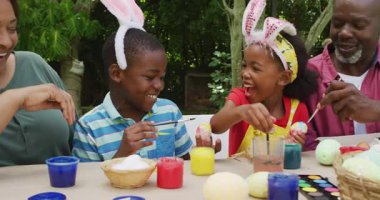 Bahçede paskalya yumurtası boyayan mutlu büyükanne ve torunların animasyonu. Aile Paskalyası, kutlama ve birlikte dışarıda kaliteli zaman geçirmek..