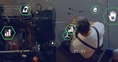 Tamirci otomotiv atölyesinde diz çöküp AR simgelerini etkinleştirirken teker çıkarmak için ingiliz anahtarını çeviriyor. Otomasyon, teknoloji, yenilik, sanayi, mühendislik, sürdürülebilirlik, dijital