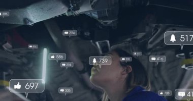 Kadın otomotiv LED ışığını yükselen arabanın altında çalıştırıyor, yükselen ve solan simgelerle kaynaklara bakıyor. Otomotiv, bakım, teftiş, büyütme, teknoloji, meslek, sanayi