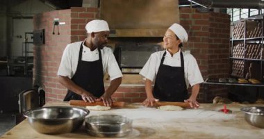 Mutlu kadın ve erkek fırıncıların ekmek için ekmek hamuru yuvarlamalarının animasyonu. Pastanede çalışmak, bağımsız küçük işletme.