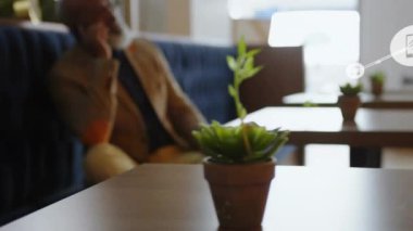 Cafe 'de telefonla arayan bir adam dolgun ağ büyümesini başlatıyor ve bağlantı simgeleri gösteriyor. Teknoloji, iletişim, ağ, modern, yaşam tarzı, bağlantı, çalışma alanı