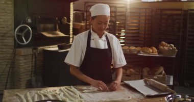 Mutlu Asyalı kadın fırıncının fırında rulo hazırlama animasyonu. Pastanede çalışmak, bağımsız küçük işletme.