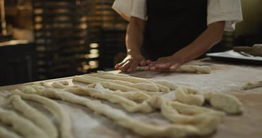 Afro-Amerikan erkek fırıncının hamur hamurunu fırında yuvarlamasının animasyonu. Pastanede çalışmak, bağımsız küçük işletme.