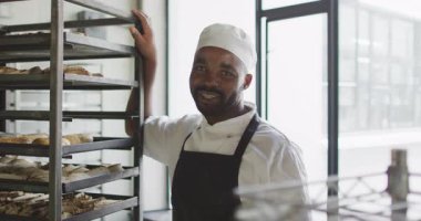 Afro-Amerikan erkek fırıncının kameraya gülümsemesinin animasyonu. Pastanede çalışmak, bağımsız küçük işletme.