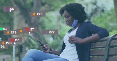 Elinde kahve tarama telefonu olan bir kadın parka geliyor ve sosyal medya uyarıları yükseliyor. Sosyal bağlantı, şehir eğlencesi, dijital etkileşim, yaşam tarzı, modern, canlı, sosyal medya