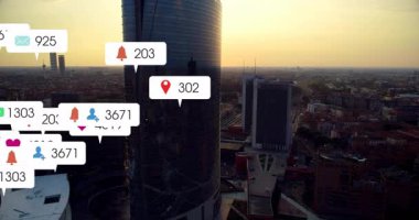 Hava görüntüsü gökdelenleri gösteriyor. Bildirimler yüzüyor, çoğalıyor ve azalıyor. Sosyal uğultuyu gösteriyor. Mimarlık, kentleşme, ufuk çizgisi, teknoloji, dijital, modern, şehir manzarası