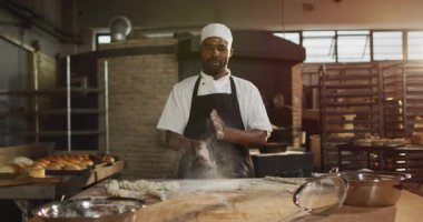 Mutlu Afro-Amerikan erkek fırıncının animasyonu. Dörtten el temizleme ve kameraya gülümseme. Pastanede çalışmak, bağımsız küçük işletme.