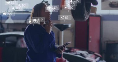 Otomobil teknisyenleri telefon dinlerken sosyal simgeler geribildirim almaya hazırlanıyor. Tamirci, otomotiv, dijital, yenilik, endüstriyel, modern, teknoloji