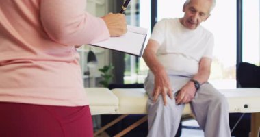 Kadın fizyoterapistin Kafkas kıdemliyi muayene edişinin videosu. Yaşlılar sağlığı ve huzurevi konsepti dijital olarak oluşturulmuş video.