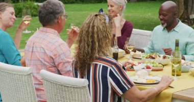 Bahçede öğle yemeği yiyen çeşitli mutlu yaşlı kadın ve erkek arkadaş animasyonları. Emeklilik yaşam tarzı, arkadaşlarla kaliteli zaman geçirme.