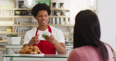 Bayan müşteriye yemek satan mutlu garsonun animasyonu. Kahve ve fil dükkanı, küçük bağımsız işler yürütüyor..