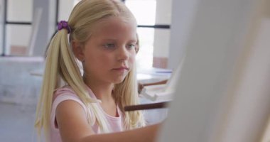 Okuldaki resim dersleri sırasında odaklanmış beyaz kız resimleri videosu. ilköğretim, bilgi ve öğrenme kavramı.