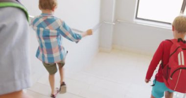 Kafkasyalı çocukların okulda alt katta yürüyüşlerinin videosu. ilköğretim, bilgi ve öğrenme kavramı.