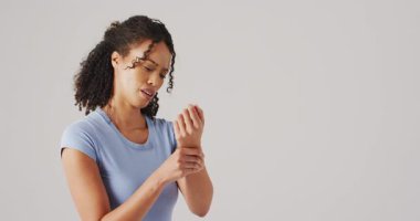 Beyaz arka planda bileğine dokunan kadının videosu. küresel tıp ve sağlık konsepti.