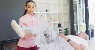 Kafkas kıdemli bir adamla egzersiz yapan mutlu kadın fizyoterapistin videosu. Yaşlılar sağlığı ve huzurevi konsepti dijital olarak oluşturulmuş video.