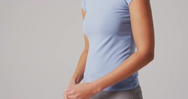 Beyaz arka planda karnına dokunan kadının videosu. küresel tıp ve sağlık konsepti.