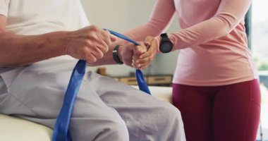 Kafkas kıdemli bir adamla egzersiz yapan mutlu kadın fizyoterapistin orta bölümünün videosu. Yaşlılar sağlığı ve huzurevi konsepti dijital olarak oluşturulmuş video.