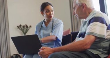Diz üstü bilgisayar kullanarak kadın doktorla konuşan mutlu, beyaz bir adamın animasyonu. Yaşlılar sağlığı ve huzurevi konsepti dijital olarak oluşturulmuş video.