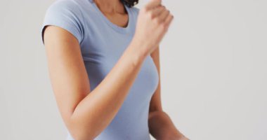 Beyaz arka planda dirseğine dokunan kadın videosu. küresel tıp ve sağlık konsepti.