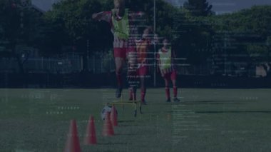 Önde gelen futbolcu engele basıyor, koşuyor, topu yakalıyor, talim için külahları sallıyor. Atletik, takım çalışması, çeviklik, eğitim, açık hava, dinamik, spor