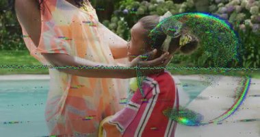 Anne kızın kafasına gözlük takıyor yüzmeye hazırlanıyor, kız annesine sarılıyor ve sağlığını koruyor. Aile, açık hava, eğlence, coşku, beslenme, sevgi, arka bahçe.