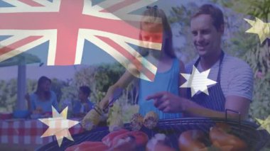 Babam, yiyecek eğitimi için Avustralya bayrağı altında mısır ızgarası hazırlayan bir kıza rehberlik ediyor. Aile, açık hava, piknik, ızgara, yaz, doğa, kutlama