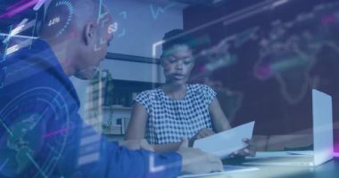 Finansal veriler üst üste gelirken, erkek, çizelgeleri analiz eden bir kadına doğru kaydırılmış rapor veriyor. İş, takım çalışması, yenilik, işbirliği, dijital, analitik, modern