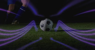 Mavi takımlı koşucu gece sahada futbol topuna yaklaşıyor, altın kramponlar, mor çizgiler. Spor, atletizm, hareket, fütüristik, rekabet, enerji, gece manzarası