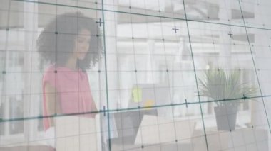 Çerçeveye doğru sürüklenen şebeke kağıtları düzenleyen ve teknoloji dairesinde dizüstü bilgisayar kullanan bir kadın olduğunu gösteriyor. Şirket, çalışma alanı, modern, minimalist, profesyonel, üretkenlik, yenilik