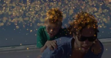 Çocuk sahilde babasına sarılıyor, hayat tarzı eğlencesi için kıvılcımlarla onu sırtında taşıyor. Eğlence, kaynaşma, aile, eğlence, açık hava, doğal eğlence