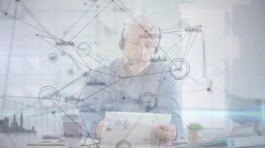 Tablet okuyan adam ağ analizi için metni eğiyor, diyagramların kulaklık çağrısına geçtiğini gösteriyor. Teknoloji, iletişim, veri, analiz, çalışma alanı, profesyonel, yenilik