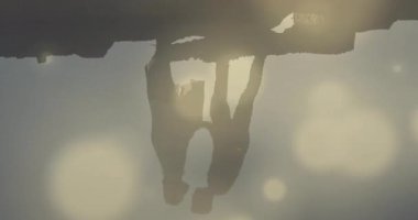 Kayalıklardaki kameralı çift, seyahat tanıtımı için öpüşen adam, hareketli lens fişekleri. Romantizm, günbatımı, samimiyet, doğa, sükunet, siluet, ahenk