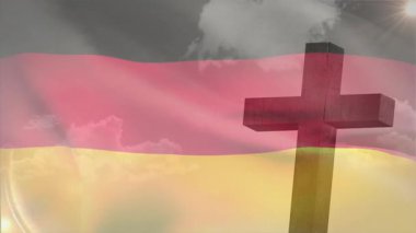 Üç renkli Alman bayrağını yakalayan rüzgar ahşap haçın yanında bulutların sallanmasına neden oluyor. Vatansever, açık hava, minimalist, sembolik, sakin, doğal, dinamik