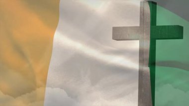 Hafif bir esinti, Fildişi Sahili bayrağının bulutlara karşı ahşap haç etrafında dalgalanmasına neden oluyor. Vatanseverlik, maneviyat, kumaş, hareket, sembolizm, doğa, sükunet