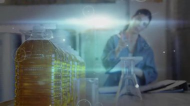 Altın likit sürahileri incelemek, laboratuvar teknisyenleri verileri kaydederken QC grafikleri çıkıyor. Laboratuvar, veri analizi, kalite kontrolü, imalat, araştırma, enstrümantasyon, sanayi