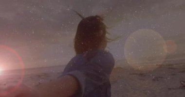 Gün batımında kumsalda kamera operatörü elini çeken bir kadın, seyahat pazarlama sahnesini mümkün kılıyor. Romantik, dostluk, macera, tasasız, esinti, günbatımı, boş zaman