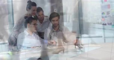 İş arkadaşı laptopun tıklayarak iş dünyasının çizelgesini açarken, akranlar kaydırıyor ve takım eğiliyor. İşbirliği, takım çalışması, yenilik, profesyonellik, modern, kurumsal, teknoloji