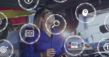 Otomobil teknisyeninin kafasını kaldırılmış arabanın altına eğmesi ve teşhis simgeleri kayıt yaparken tableti tıklaması. Teknoloji, otomotiv, onarım, yenilik, endüstri, çalışma alanı, eğitim