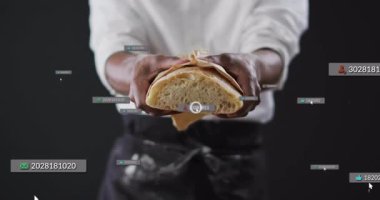 Şefin elinde yarım somun ekmek, soluk sayısal rozet iş için verileri örtüyor. Mutfak, gurme, rustik, dijital, teknoloji, modern, profesyonel