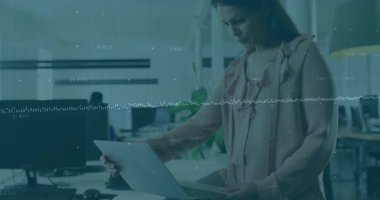 Yetişkin bir kadın masadan kaldırıyor ve iş verilerini canlı dalga formu kaplamalarıyla inceliyor. Teknoloji, yenilik, işbirliği, üretkenlik, modern, profesyonellik, çalışma alanı