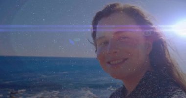 Teknoloji gösterisinde kadının arkasında güneş parlıyor. Kafası açılırken lensler kayıyor. Deniz manzarası, güneş ışığı, dinginlik, doğa, yansıma, ufuk, yaşam tarzı.