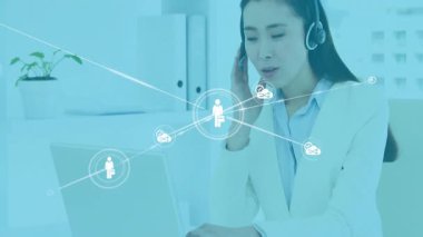 Kulaklığa konuşurken dizüstü bilgisayarda yazan ve ağ simgelerini genişleten müşteri destek ajanı. Teknoloji, iletişim, bağlantı, dijital, ofis, işbirliği, yenilik