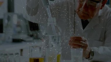 Üst düzey bilimadamı deney şişelerini hizalıyor sonra da örnek almak için sarı çözeltiyi şişeye yerleştiriyor. Araştırma, deney, kesinlik, yenilik, bilimsel, analitik, laboratuvar